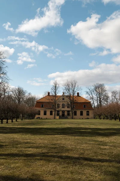 LIEPUPE, LATVIA - 13 de abril de 2019: Liepupes Muiza mansão em belo tempo ensolarado Primavera com céu azul e nuvens — Fotografia de Stock