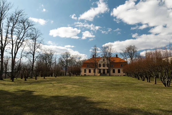 LIEPUPE, LATVIA - 13 de abril de 2019: Liepupes Muiza mansão em belo tempo ensolarado Primavera com céu azul e nuvens — Fotografia de Stock