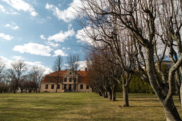 LIEPUPE, LATVIA - 13 de abril de 2019: Liepupes Muiza mansão em belo tempo ensolarado Primavera com céu azul e nuvens — Fotografia de Stock