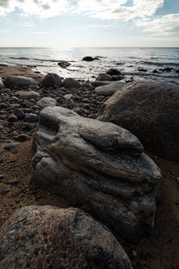 Veczemju Klintis-Nisan 2019 Baltık ülkesinde Letonya Boulder plaj-donuk bulutlar ve güneş biraz bulutlu gökyüzü