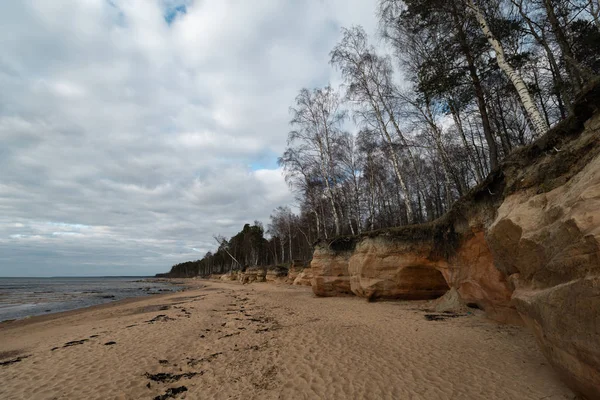 Wapienne plaży nad Morzem Bałtyckim z pięknym wzorem piasku i żywe czerwony i pomarańczowy kolor-pisma turystyczne na ścianach i kamieniach i piasku-Veczemju Klintis, Łotwa-13 kwietnia 2019 — Zdjęcie stockowe