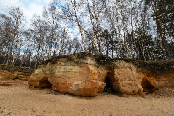 Mészkő strand a Balti-tengeren gyönyörű homok mintás és élénk piros és narancssárga színű-turisztikai írások a falakon és a homok-Veczemju Klintis, Lettország-április 13, 2019 — Stock Fotó