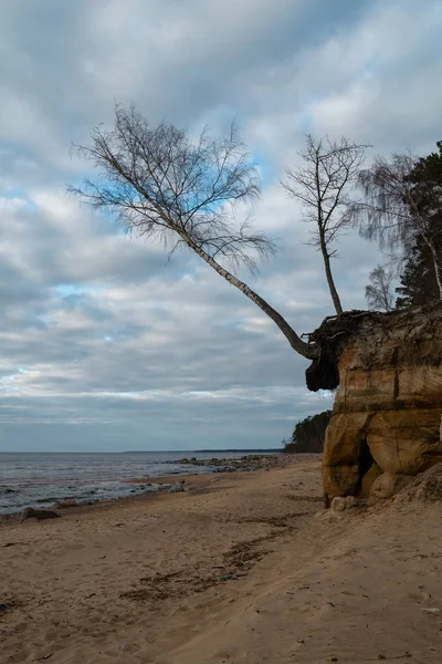 Mészkő strand a Balti-tengeren gyönyörű homok mintás és élénk piros és narancssárga színű-turisztikai írások a falakon és a homok-Veczemju Klintis, Lettország-április 13, 2019 — Stock Fotó