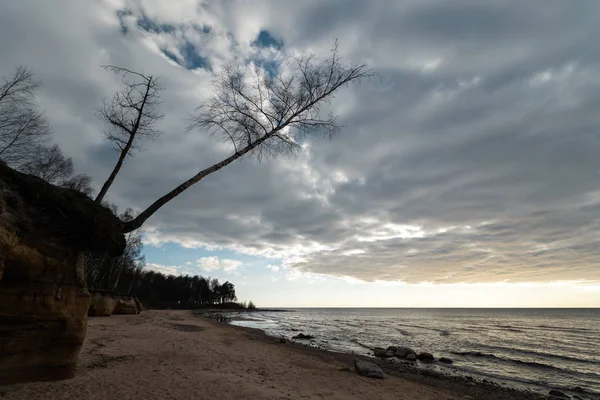 Wapienne plaży nad Morzem Bałtyckim z pięknym wzorem piasku i żywe czerwony i pomarańczowy kolor-pisma turystyczne na ścianach i kamieniach i piasku-Veczemju Klintis, Łotwa-13 kwietnia 2019 — Zdjęcie stockowe