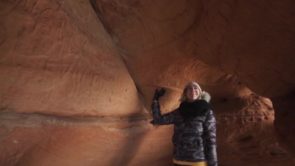 Curious young female archaeologist exploring a sand cave - Veczemju Klintis, Latvia - April 13, 2019 — Stock Video