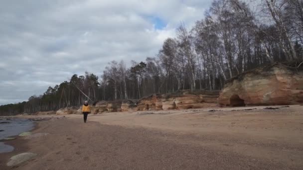 Glückliche junge modesüchtige Frau beim Sport am Strand bei kaltem Frühlingswetter - veczemju klintis, Lettland - 13. April 2019 — Stockvideo