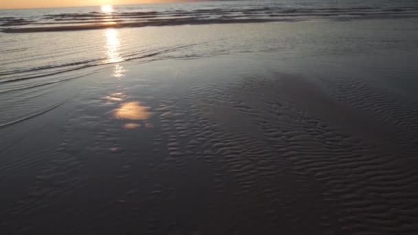 Coucher de soleil cramoisi avec ciel clair et miroir comme des reflets dans l’eau-sable côtelé et vagues-Tuja, Lettonie-13 avril 2019 — Video