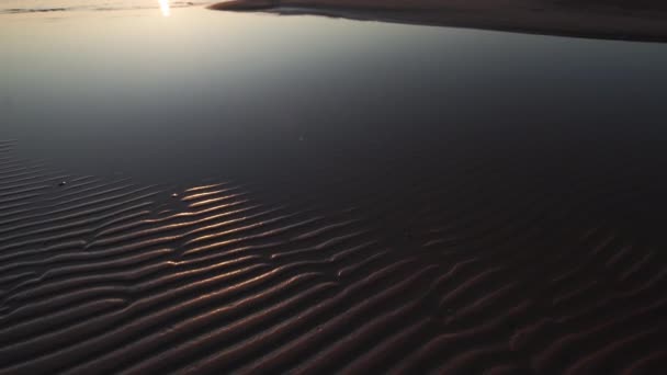 Pôr do sol carmesim com céu claro e espelho como reflexos na água - Areia com nervuras e ondas - Tuja, Letônia - 13 de abril de 2019 — Vídeo de Stock