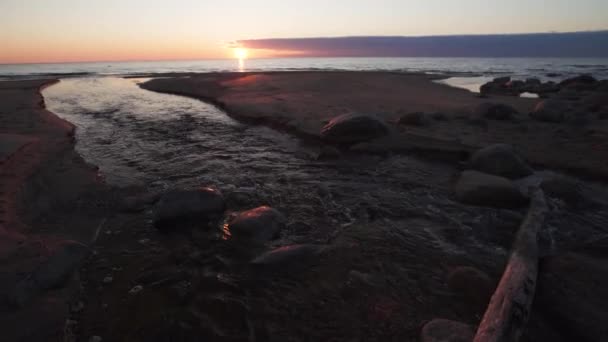 Beau coucher de soleil avec des couleurs rouges-l’eau spting entrant dans la mer-Tuja, Lettonie-13 avril 2019 — Video