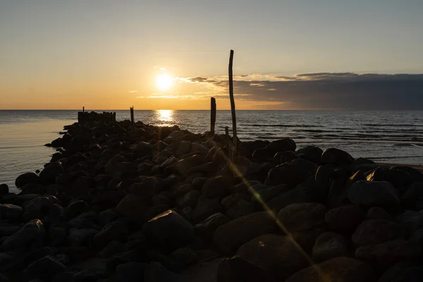 Boulder beach molo tramonto con colori vivaci rosso e arancione sul Mar Baltico - Tuja, Lettonia - Aprile 13, 2019 — Foto Stock