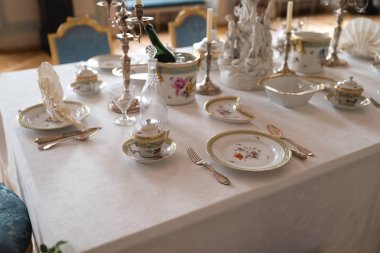 Bir sarayda pahalı Retro Kraliyet Majesteleri porselen servis plakaları ve çatal ile düğün masası dekorasyon