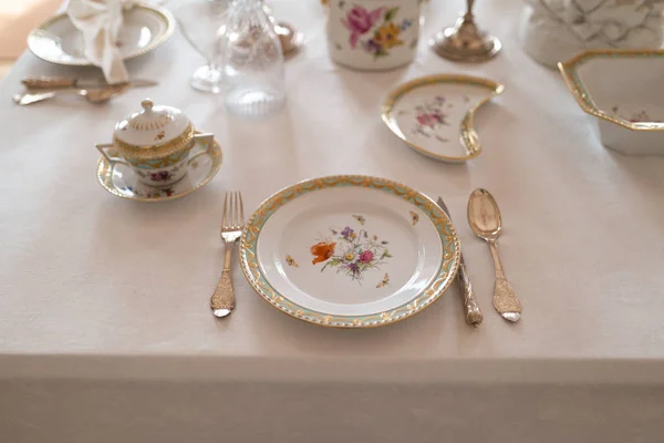 Bir sarayda pahalı Retro Kraliyet Majesteleri porselen servis plakaları ve çatal ile düğün masası dekorasyon