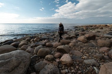 Baltık Denizi kıyısında egzotik kayalar arayan genç bir arkeolog.