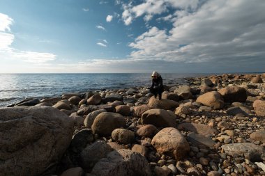 Baltık Denizi kıyısında egzotik kayalar arayan genç bir arkeolog.