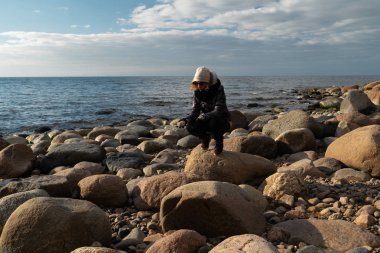 Baltık Denizi kıyısında egzotik kayalar arayan genç bir arkeolog.