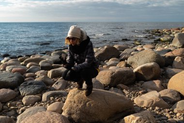 Baltık Denizi kıyısında egzotik kayalar arayan genç bir arkeolog.