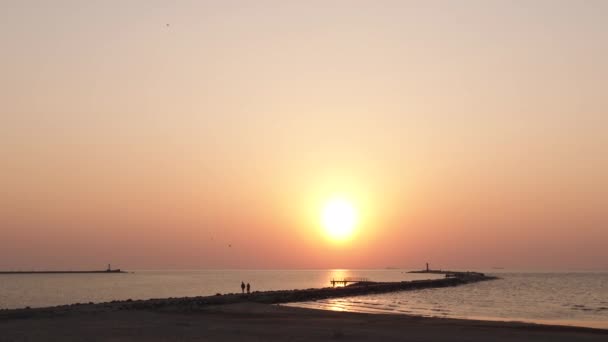 Phare lors d'une dernière minute de coucher de soleil avec un grand soleil proche de l'horizon et un ciel clair — Video