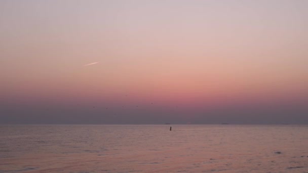 Tramonto rosa e un ultimo secondo di sole rosso visibile all'orizzonte — Video Stock