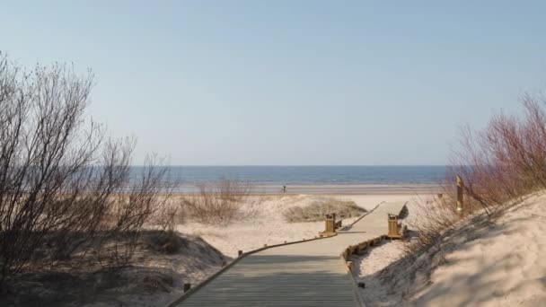 Nuova strada di legno che conduce dalla foresta di dune spiaggia con pini e bianco inviato al golfo del Mar Baltico - Vecaki, Lettonia — Video Stock