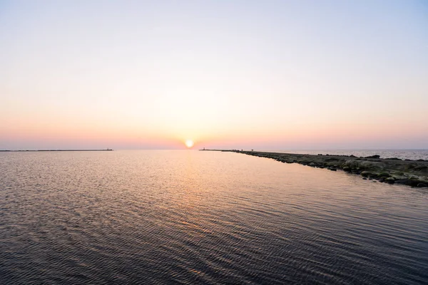 Faro durante un ultimo minuto di tramonto con un grande sole vicino all'orizzonte e cielo limpido — Foto Stock