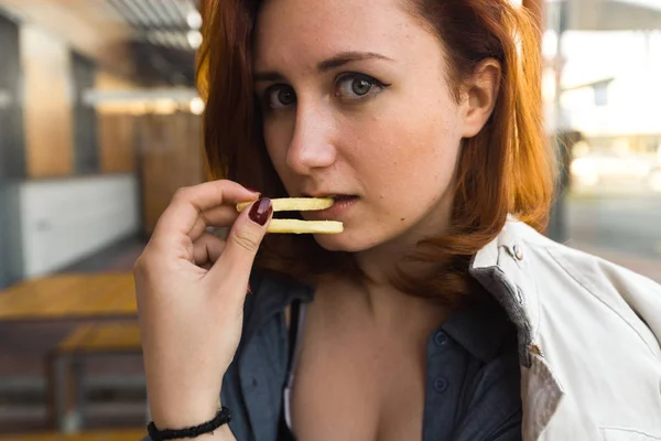 炸土豆特写面 - 吃和享受 - 年轻女子在快餐店吃 - 奶酪汉堡，中等薯条和苏打水 — 图库照片