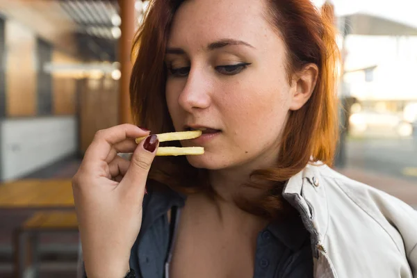 Pommes aus nächster Nähe - Essen und Genießen - junge Frau isst im Fast-Food-Restaurant - Cheeseburger, mittelgroße Pommes und Limo — Stockfoto