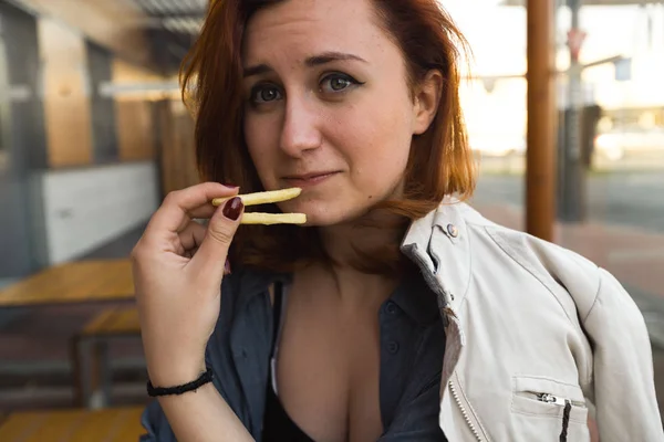 Картопля фрі крупним планом - Їжа та насолода - Молода жінка, що їсть у ресторані Fast Food - Cheeseburger, середня картопля фрі та сода — стокове фото