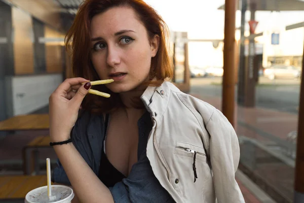 Pommes aus nächster Nähe - Essen und Genießen - junge Frau isst im Fast-Food-Restaurant - Cheeseburger, mittelgroße Pommes und Limo — Stockfoto