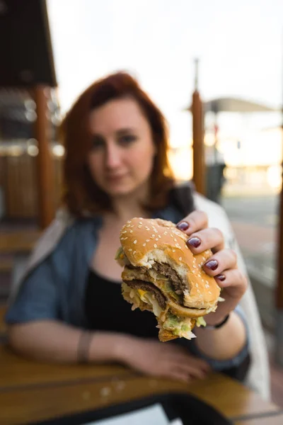 Hamburger yakın - Fast Food Restaurant'ta yemek yiyen Genç Kadın - Cheeseburger, orta boy patates kızartması ve soda
