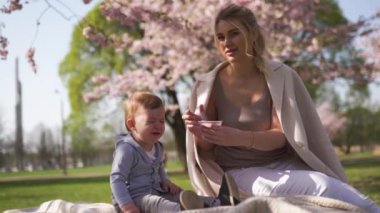 Sakura Cherry Blossom - Genç anne riga, Letonya Avrupa'da bir parkta onun küçük oğlu oğlu ile oturan