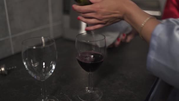 Frauen gießen aus nächster Nähe Rotwein in Gläser - zwei leere Weingläser — Stockvideo