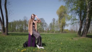 Genç mutlu gezgin yeni varış ülkesine geldi - otobüs taksisini beklerken - beyaz, uzun saçlı, açık renk sutyen ve bej ceketli bir kadının duyguları