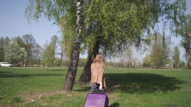 Genç mutlu gezgin yeni varış ülkesine geldi - valiziyle yürüyordu - beyaz, uzun saçlı, açık renk sutyen ve bej ceket giyen beyaz, beyaz, beyaz, beyaz bir kadının duyguları