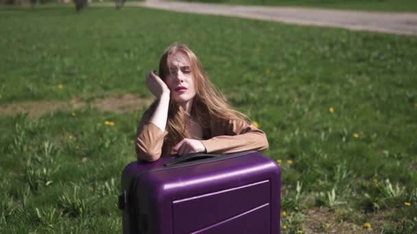 Viajero triste perdió su vuelo y autobús - Sentada en su maleta de equipaje y llorando - Emociones de una mujer blanca caucásica con el pelo largo ligero wearng sujetador y chaqueta beige — Vídeo de stock