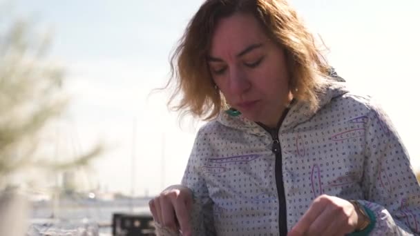 Gelukkige reiziger eten ribben plaat in een restaurant-golvend bruin haar, blanke blanke vrouwelijke vrouw dragen lichte jas in het voorjaar Sunny — Stockvideo