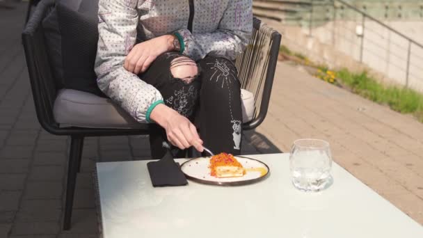 Gelukkige reiziger eten zoete cake dessert in een restaurant-golvend bruin haar, blanke blanke vrouw vrouw dragen lichte jas in het voorjaar Sunny — Stockvideo