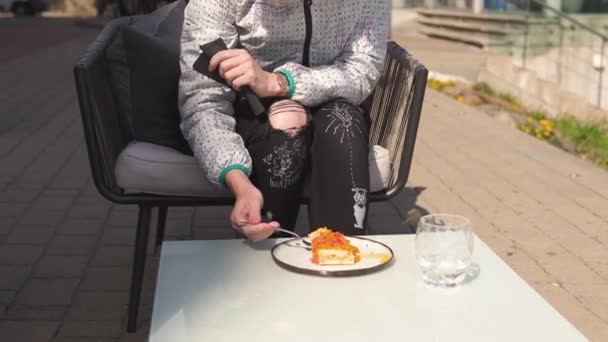 Heureux voyageur manger dessert gâteau sucré dans un restaurant - cheveux bruns ondulés, femme blanche caucasienne portant une veste légère au printemps ensoleillé — Video