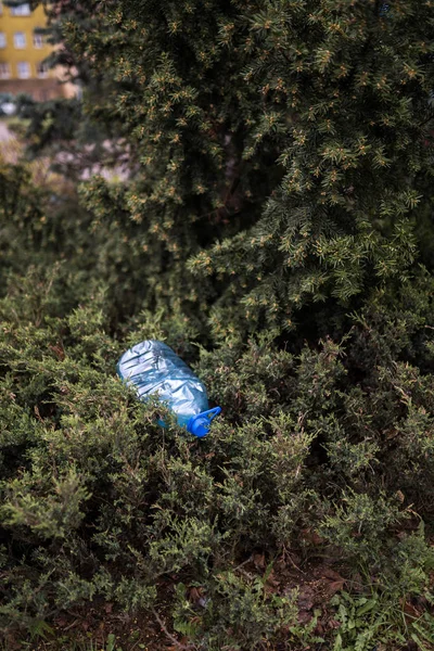 Garrafa de plástico grande azul que jaz no chão em árvore em uma floresta de parque - Lançada fora não reciclada - Lixo e poluição da cidade e da natureza - Lixo deteriorado — Fotografia de Stock