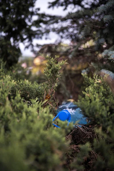 공원 숲에서 나무에 땅에 누워 파란색 큰 플라스틱 병 - 재활용되지 밖으로 던져 - 쓰레기와 도시와 자연의 오염 - 부패 쓰레기 — 스톡 사진