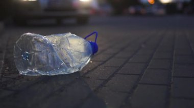 Plastik şişe bir araba önünde gece yerde yatan - Geri dönüşümlü değil dışarı atılmış - Çöp ve şehir ve doğanın kirliliği - Çürümüş çöp