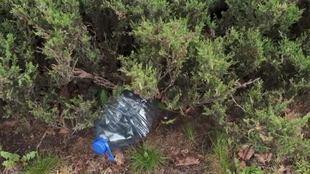Niebieska duża plastikowa butelka leżąca na ziemi w drzewie w parku leśnym-wyrzucona z recyklingu-Śmietnik i zanieczyszczenie miasta i przyrody-zbutwiałe śmieci — Wideo stockowe