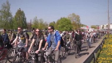 Riga, Letonya - 1 Mayıs 2019: Diğer arabalar ve trafik ile kamusal alan yolda aileler ve arkadaşlar ile İşçi Günü Bisiklet geçit töreni