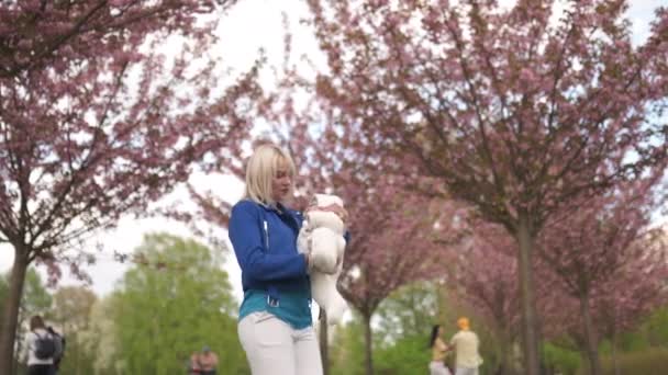 Joven madre mujer disfrutando de tiempo libre con su bebé niño niño blanco caucásico con una mano de los padres visible Vestido de blanco en general con corazones, mamá en azul — Vídeo de stock