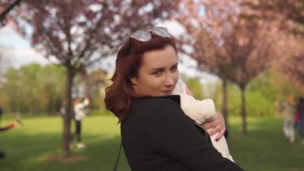 Young mother woman enjoying free time with her baby boy child - Caucasian white child with a parents hand visible - Dressed in white overall with hearts, mom in blue — 비디오