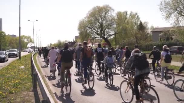 RIGA, LATVIA - MAIO 1, 2019: Desfile de bicicleta no dia do trabalho com famílias e amigos na estrada do espaço público com outros carros e tráfego — Vídeo de Stock