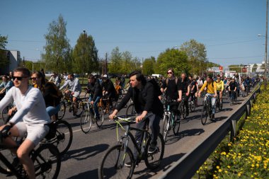 Riga, Letonya - 1 Mayıs 2019: Diğer arabalar ve trafik ile kamusal alan yolda aileler ve arkadaşlar ile İşçi Günü Bisiklet geçit töreni