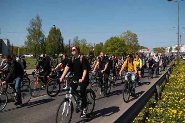 Riga, Letonya - 1 Mayıs 2019: Diğer arabalar ve trafik ile kamusal alan yolda aileler ve arkadaşlar ile İşçi Günü Bisiklet geçit töreni