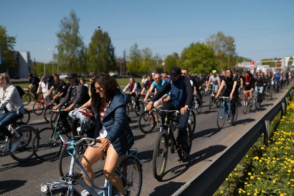 Riga, Letonya - 1 Mayıs 2019: Diğer arabalar ve trafik ile kamusal alan yolda aileler ve arkadaşlar ile İşçi Günü Bisiklet geçit töreni