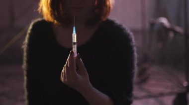 Şırınga siyah kazak giyen bir uyuşturucu bağımlılığı kızıl beyaz beyaz genç kadın elinde yakın - Anksiyete, depresyon ve tehlike hissi
