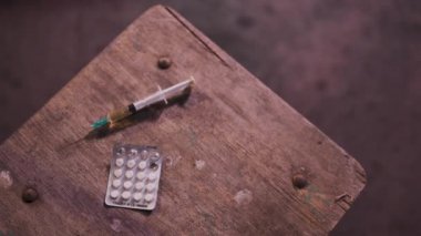 Siyah kazak, etek ve chocker giyen etrafında yürüyüş bir uyuşturucu bağımlılığı kızıl beyaz beyaz genç kadın ile masadan dolu şırınga kapma - Anksiyete, depresyon ve tehlike hissi